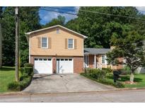 Charming two-story home featuring an attached two-car garage and well-maintained front yard at 4402 Autumn Hill Drive, Stone Mountain, GA 30083