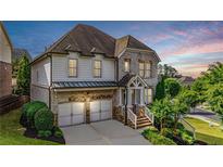 Charming two-story home featuring a two-car garage and beautifully landscaped front yard with stone and siding accents at 11760 Stratham Dr, Alpharetta, GA 30009