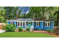 Charming blue home with a well-maintained front yard and a vibrant turquoise front door at 1718 Cahoon Sw St, Atlanta, GA 30310
