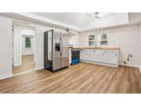 Open kitchen featuring stainless steel refrigerator, ample cabinets, and hardwood flooring at 2155 S Deshon S Rd, Lithonia, GA 30058