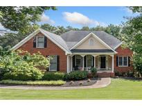 Charming single Gathering brick home with well-manicured lawn and inviting front porch seating area at 207 Breckenridge Ct, Canton, GA 30115