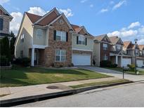 Charming two-story home with stone accents, attached garage, and landscaped front yard at 735 Briarhurst Ct, Lawrenceville, GA 30046