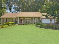 Charming single-story home featuring a well-manicured front lawn and an attached two car garage at 2251 Stag Run Run, Suwanee, GA 30024