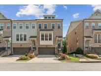 Charming brick townhome showcasing a desirable exterior with landscaped grounds and attached garages at 2372 Se Montford Place Se Pl, Smyrna, GA 30080