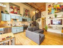 Open-concept living space featuring spiral staircase, modern kitchen, exposed brick, and eclectic decor at 10 James St # 11B, Hampton, GA 30228
