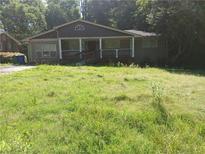 Charming home with a front porch and overgrown front yard, perfect for renovation at 3072 Will Rogers Se Pl, Atlanta, GA 30316
