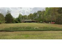 Charming single-story home with an attached carport and a lush green front yard at 820 Bennett Rd, Powder Springs, GA 30127