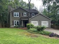 Charming two-story home featuring an attached two-car garage and a lush green lawn at 2105 Windy Oak Ct, Lithia Springs, GA 30122