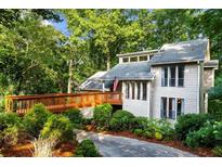 Charming two-story home with lush landscaping, a wooden bridge entrance, and lovely architectural details at 634 Green Valley Dr, Smyrna, GA 30082