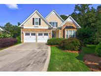 Charming home featuring a two-car garage, stone accents, and manicured landscaping at 490 Grand Teton Cir, Fayetteville, GA 30215