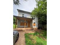 Charming two-story home with a cozy front porch and unfinished yard and boarded up windows at 7 Charleston Se Ave, Atlanta, GA 30315