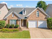 Charming brick home featuring a well-manicured lawn and an attached two-car garage at 137 Hidden Lake Cir, Canton, GA 30114