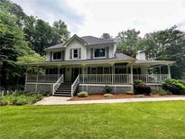 Charming two-story home featuring a sprawling front porch and meticulously maintained lawn at 3970 Governor'S Circle, Loganville, GA 30052