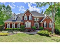 Traditional brick home with manicured lawn and landscaping, complemented by a welcoming entrance at 320 Chason Wood Way, Roswell, GA 30076