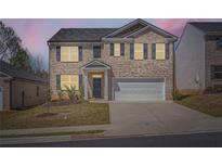 Charming two-story brick home with a two-car garage and well-maintained front lawn at 1936 Waycross Ln, Dacula, GA 30019