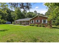 Charming one-story brick home with white shutters and a lush green lawn at 1051 Rock Springs Rd, Lawrenceville, GA 30043