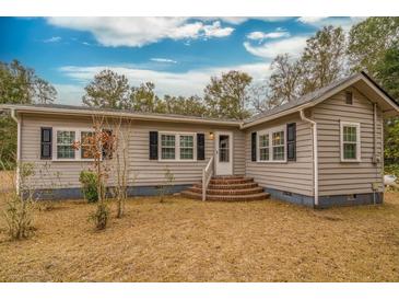 Ranch style home with brick steps, grey siding, and black shutters at 8375 Shell House Rd, Edisto Island, SC 29438