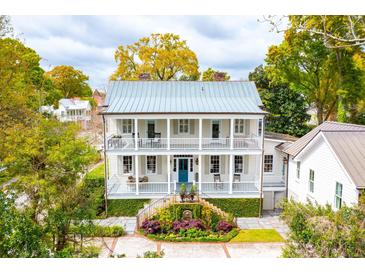Two-story home with wraparound porch, metal roof, and landscaped yard at 436 Church St, Mount Pleasant, SC 29464