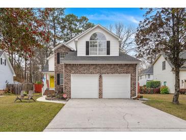 Two-story brick home with a two-car garage and well-manicured lawn at 1005 Shinnecock Hills Ct, Summerville, SC 29483