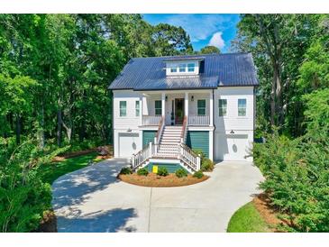 Two-story home with metal roof, green accents, and a circular driveway at 4858 Marshwood Dr, Hollywood, SC 29449