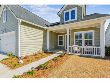 Green house with white trim, a front porch, and landscaped yard at 1104 Cooper Point St, Summerville, SC 29485