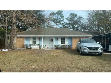 Brick ranch home with light blue siding, and a partially visible SUV in the front yard at 303 Longleaf Rd, Summerville, SC 29486