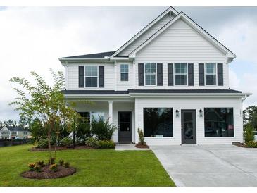 Two-story white house with gray shutters, landscaping, and a driveway at 778 Opal Wing St, Moncks Corner, SC 29461