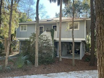 Gray two-story house with white trim, elevated foundation, and surrounding trees at 61 Twin Oaks Ln, Isle of Palms, SC 29451
