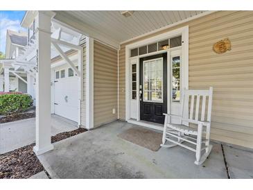 Inviting front porch with rocking chair, entrance, and attached garage at 9632 Scarborough Ct, Summerville, SC 29485
