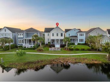 Aerial view of charming house with water feature and landscaped surroundings at 1583 Paradise Lake Dr, Mount Pleasant, SC 29464