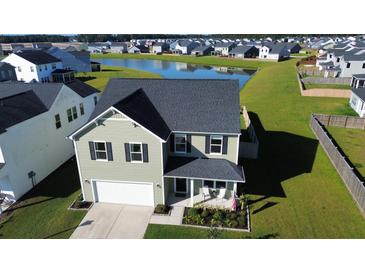 Two-story house with a gray roof and white garage, situated on a landscaped lawn near a pond at 268 Lucca Dr, Summerville, SC 29486
