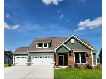 Two-story craftsman style home with stone and green siding, two-car garage, and manicured lawn at 270 Darby Meadow Ln, Ridgeville, SC 29472
