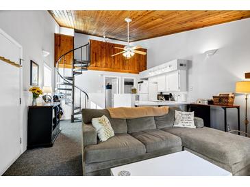 Cozy living room with spiral staircase, vaulted ceiling, and comfy seating at 279 Driftwood Ln, Edisto Beach, SC 29438