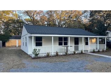 Charming white cottage with a front porch and well-maintained landscaping at 5614 Read St, North Charleston, SC 29406