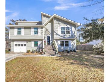 Two-story house with gray siding, brick steps, and a white garage door at 8048 New England Dr, North Charleston, SC 29420