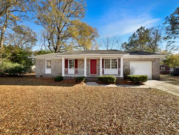 Brick ranch house with red door, covered porch, and landscaped yard at 3 Tommy Cir, Goose Creek, SC 29445