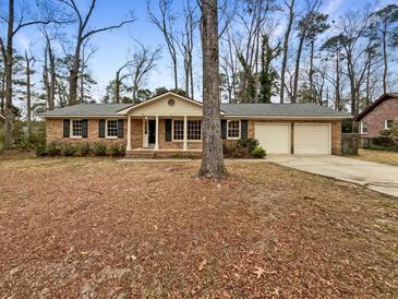 Brick ranch house with attached two-car garage and mature trees at 105 Gambels Ln, Summerville, SC 29485