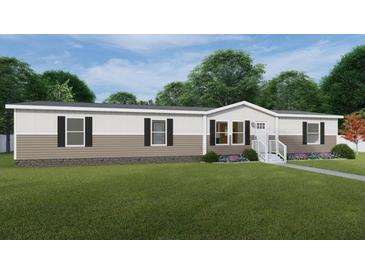 Two-toned manufactured home with gray and beige siding, black windows, and a landscaped yard at 126 Addison Rd, Harleyville, SC 29448