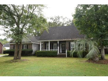 Brick house with front porch, landscaping, and large trees at 8245 Governors Walk, North Charleston, SC 29418