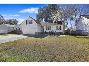 Beige house with a garage and patio, well-maintained lawn at 9609 Crosscut Dr, Ladson, SC 29456