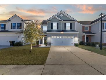 Two-story house with gray siding, white garage door, and landscaped lawn at 241 Swamp Creek Ln, Moncks Corner, SC 29461