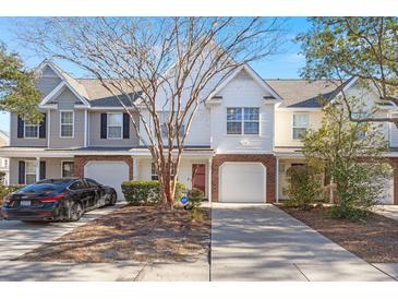Three-unit townhouse building, brick and siding exterior, attached garages, landscaping at 5222 Chicory Ln, North Charleston, SC 29420