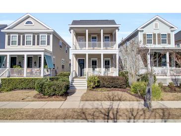 Two-story tan house with white columns, porch, and landscaping at 1040 Hills Plantation Dr, Charleston, SC 29412