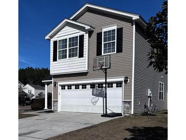 Two-story house with gray siding, white garage door, and basketball hoop at 356 Peters Creek Dr, Summerville, SC 29486