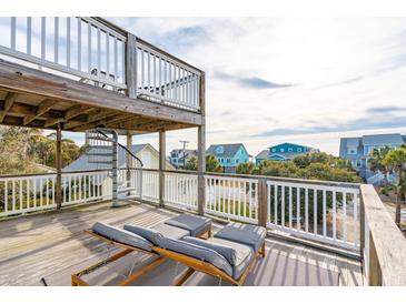 Relaxing deck with wooden chairs, offering scenic neighborhood views at 904 E Arctic Ave, Folly Beach, SC 29439