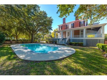 Inviting kidney-shaped pool surrounded by lush landscaping at 927 Fishburne Rd, Pinopolis, SC 29469