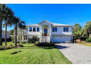 Two-story home with white siding, metal roof, and a brick driveway at 3 43Rd Ave, Isle of Palms, SC 29451