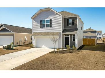Two-story house with gray and beige siding, a white garage door, and landscaping at 307 Black Birch Dr, Summerville, SC 29486
