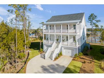 Two-story home with a wrap-around porch, double garage, and waterfront views at 3578 Clambank Dr, Mount Pleasant, SC 29466