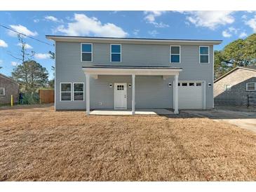 Two-story house with gray siding, a covered porch, and a two-car garage at 5889 N Rhett Ave, Hanahan, SC 29410